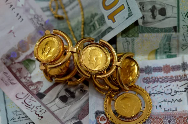 埃及镑和沙特阿拉伯里亚尔纸币货币与英国主权金币构成的金币形状的金币乔治珠宝或珠宝 黄金价格 — 图库照片