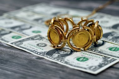 Amerikan dolarlarındaki mücevher veya mücevherler nakit para banknotu, İngiliz altın sikkeleri külçe para şekilleri George ve ejderha, Amerikan doları ve enflasyon konsepti olarak altın fiyat