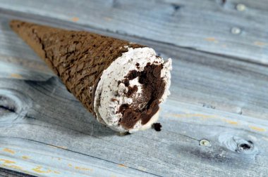 Kakao çikolatalı dondurma ve çikolatalı kurabiye parçalı vanilyalı dondurma gevrek külahta, erimiş dondurmalı kurabiye, yaz tatili konsepti.