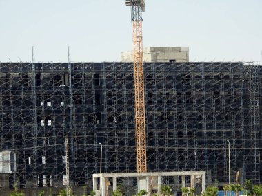 Vinç kulesi ve binanın çimento beton mimarisi olan yeni bir inşaat alanı iskelelerle çevrili, yeni gayrimenkul geliştirme yükselişi