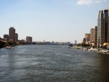 Kahire, Mısır, 29 Haziran 2023: Mısır Nil Nehri Nil Nehri, Nil kıyısı boyunca modern binalar ve köprüler ve Mısır nehir kıyısında Mısır Nil Nehri 'nin güpegündüz yürümesi.