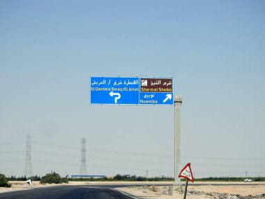Güney Sina, Mısır, 30 Haziran 2023: Güney Sina 'da bir yön tabelası, Arapça ve İngilizce yazılan otoyolda Sharm El Sheikh, Doğu Kantara, Arish ve Nuweiba şehirlerini tarif eder.