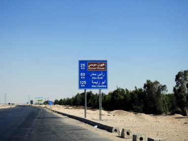 Güney Sina, Mısır, 30 Haziran 2023: Arapça ve İngilizce bir trafik levhası Oyoun Mousa 25 km, Ras Sudr şehri 60 km ve Abu Zenima 125 km uzaklığını gösteriyor.