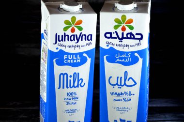 Kahire, Mısır, 18 Haziran 2023: Juhayna tam kremalı süt şişesi 1,5 litre kalsiyum ve vitaminli, seçici odak Johayna doğal sütü ahşap arka planda izole edilmiş