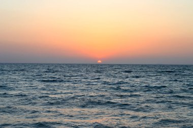 Güney Sina sahilinde günbatımı, Mısır 'daki kızıl denizin kıyısında gece olmadan batan güneş, altın rengin sonunda gökyüzünde alacakaranlık görülebiliyordu, seçici bir odak noktası.