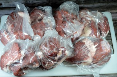 Taze et çorbası yapmak için sıcak suda kaynatılıp pişirilmeye hazır taze et yığını veya çeşitli mutfaklarda pişirilmeye hazır, yağ tabakasıyla kaplı çiğ et seçici odak noktası.