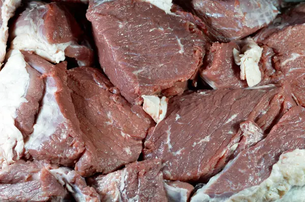 新鮮な肉汁を作るために または様々な料理で調理するためにお湯で調理し 沸騰させる準備ができて作品に刻まれた新鮮な牛肉の赤肉の山 脂肪層で覆われた生肉の選択的な焦点 — ストック写真