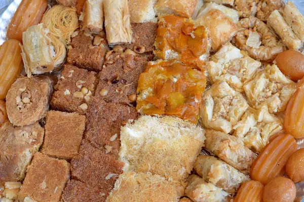 stock image Arabic sweets cuisine, middle eastern, Syrian, Egyptian and Turkish desserts of delicious collection of Ramadan traditional desserts, basbosa, konafa, baklava, tulumba and Zalabia served with nuts