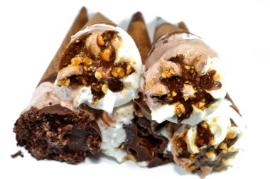 Dondurma, vanilya ve çikolata külahları. Çikolata, karamel sosu ve gevrek bir külahta fındık. Soğuk dondurmayı bisküvinin içinde eritmek, yaz tatili kavramı.