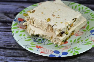 Antep fıstıklı ya da Halawa Tahiniya 'lı geleneksel tahin halkası, bu şekerin ana bileşenleri susam yağı veya yapıştırıcı (tahini) şeker, glikoz veya bal, temel tahini ve şeker bazlıdır.