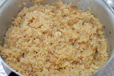 Beyaz Mısır pirincini sıcak buharla pişirmiş ve soğandan kahverengi renk almış, genellikle deniz ürünleri, balık ve karides, Ramazan yemeği konsepti, Mısır mutfağı arka planı ile pişirilmiş.