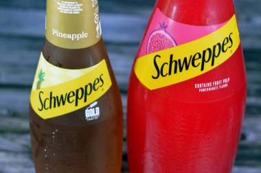 Giza, Mısır, 21 Temmuz 2023: Schweppes premium köpüklü meşrubat, altın ananas ve nar aromalı Schweppes, 1783 yılında Cenevre Cumhuriyeti 'nde kurulmuş bir içecek markasıdır.