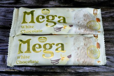 Kahire, Mısır, 22 Temmuz 2023: Nestle Mega Vanilyalı bademli dondurma çubuğu, fındıklı beyaz çikolata tabakasıyla kaplı, çikolata aromalı dondurma, kızarmış badem.