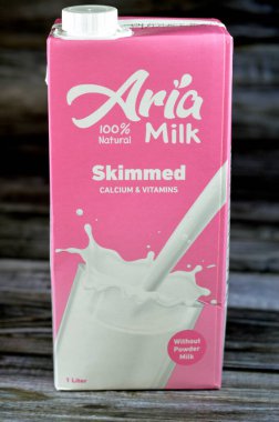Kahire, Mısır, 25 Temmuz 2023: Aria, kalsiyum ve vitaminli taze inek sütü şişesinin kaymağını yedi, Aria 'nın seçici odak noktası, ahşap arka planda izole edilmiş doğal süt.