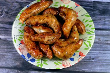 Mısır usulü, içi baharatlı pirinç, otlar, soğan ve domatesle dolu bağırsaklarla dolu, bol yağda kızartılmış, seçici bir odaklanma olan içi doldurulmuş mumya sosisi.