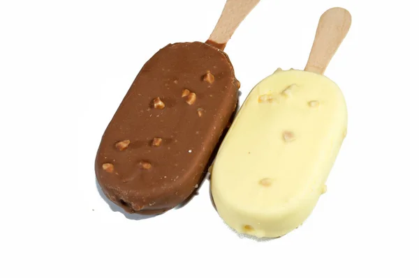 ブラウンチョコレートとホワイトミルクチョコレートとローストアーモンドでリッチバニラ風味のアイスクリーム バニラアイスクリームスティックコーティングされ ナッツで濃くて白いチョコレートの層で覆われています — ストック写真