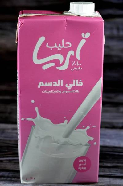 stock image Cairo, Egypt, July 25 2023: Aria skimmed fresh cow's milk carton bottle of 1 one Liter litre with Calcium and vitamins, selective focus of Aria natural milk isolated on wooden background