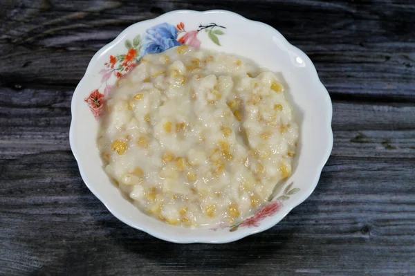 Sobremesa brasileira doce de abóbora coco e canela em uma tigela e mesa de  madeira