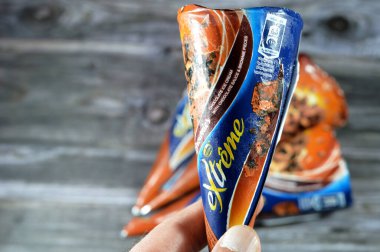 Kahire, Mısır, 27 Temmuz 2023: Ekstrem Nestle çikolatalı dondurma külahı üzerinde çikolata sosu ve çikolatalı kek parçaları gevrek bir gofret külahında erimiş soğuk dondurmalı bisküvi