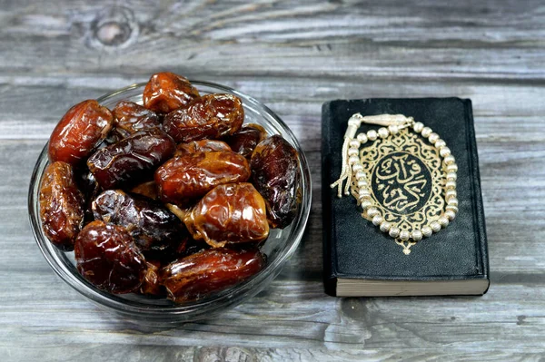 Ramadan background, Ajwa dates, a cultivar of the palm date used in iftar, The holy Quran, Qur\'an or Koran (the recitation) is the central religious text of Islam and an Islamic silver rosary