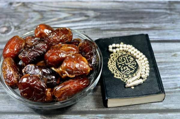 Ramadan background, Ajwa dates, a cultivar of the palm date used in iftar, The holy Quran, Qur'an or Koran (the recitation) is the central religious text of Islam and an Islamic silver rosary