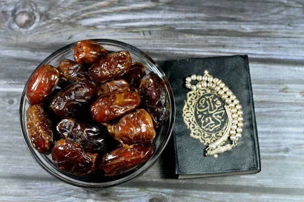 Ramadan background, Ajwa dates, a cultivar of the palm date used in iftar, The holy Quran, Qur'an or Koran (the recitation) is the central religious text of Islam and an Islamic silver rosary