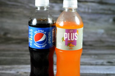 Kahire, Mısır, 29 Temmuz 2023: Pepsi, kola aromalı plastik şişe, PepsiCo tarafından üretilen karbonatlı meşrubat. ve Mirinda Plus mandalina sodası ile İspanya 'da normal olarak üretilen meyve suyu.