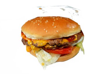 Sosu peynirle kaplı sulu, kalın, çift etli köfte, çıtır marul, taze domates, soğan ve turşu, büyük susamlı çörek, özel soslu sığır burger sandviçi.