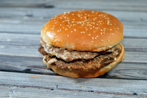 Double juicy thick beef patty with cheese covered with sauce, mushroom in a large sesame seed bun, a beef burger hamburger sandwich with special sauces in a sesame bun, selective focus