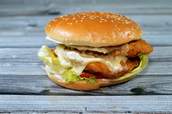 A delicious combination of fried breaded chicken fillet patties, crisp lettuce, melting cheese, onions and sauce framed between a toasted sesame seed bun. double chicken fillet burger sandwich,