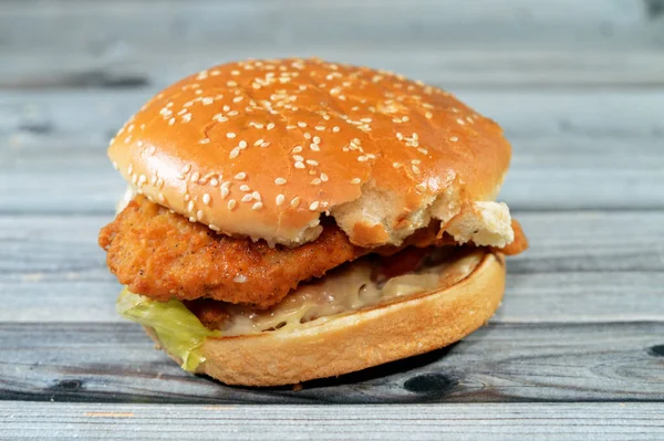 A delicious combination of fried breaded chicken fillet patties, crisp lettuce, melting cheese, onions and sauce framed between a toasted sesame seed bun. double chicken fillet burger sandwich,
