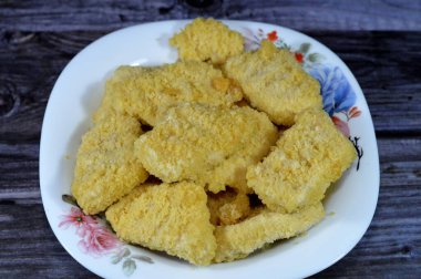 Bir tabak tavuk nugget tamamen pişmiş taze tavuk eti çeşnili ve lezzetli çıtır ekmek kırıntıları, tavuk parmakları, fileto ya da goujonlar ile kaplı beyaz tavuk etidir.