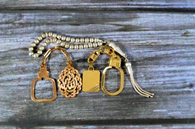 Altından yapılmış gümüş bir tespih ve altın anahtarlık madalyası 18 karatlık arapça bir metinde Allahu Ekber çevirisi (Allah en büyüktür), altın döviz kuru, ticaret, altın konsept fiyatı