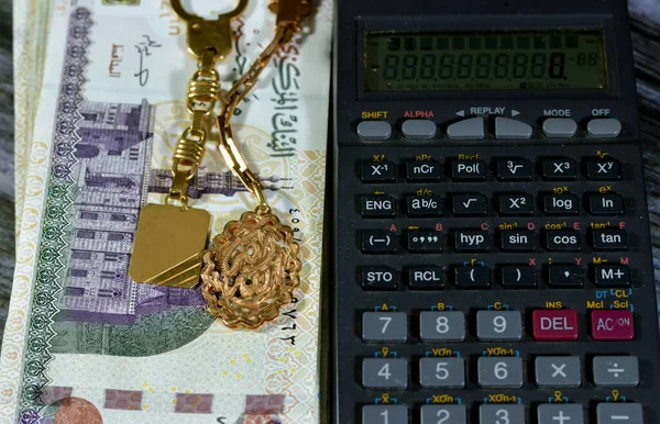 埃及一计算器和黄金钥匙扣金币 金卡拉特18号 阿拉伯文本阿拉胡阿克巴翻译 上帝是最伟大的 上面堆放着200埃及镑的埃及镑 埃及货币与黄金的汇率 — 图库照片
