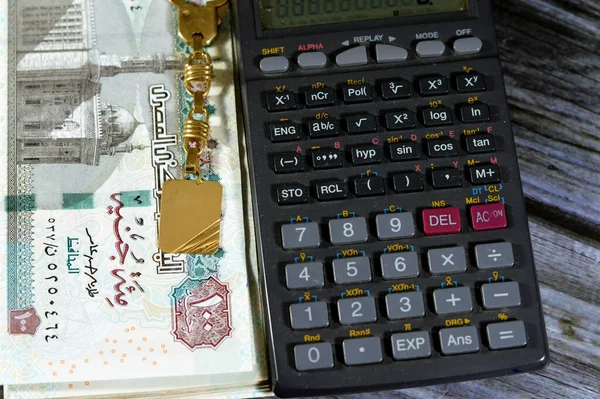 100埃及镑钞票100埃及镑 用计算器和金钥匙扣 埃及镑汇率和黄金价格概念的钞票堆放埃及现金钞票 — 图库照片