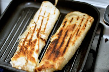 Suriye mutfağının arka planı, tavuklu shawerma veya soğanlı shawarma tortilla dürümü, domates, marul ve sarımsak sosu Suriye ekmeğinde ızgara ve servis edilmeye hazır, seçici odaklanma