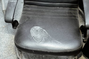 Deri sandalyede ayak izi, tozlu sandalyede kirli ayakkabı izi iz, iz sürme, ayak izi, iz sürme ve olay yeri konsepti, adli tıp ayrıntıları, seçici odaklanma.