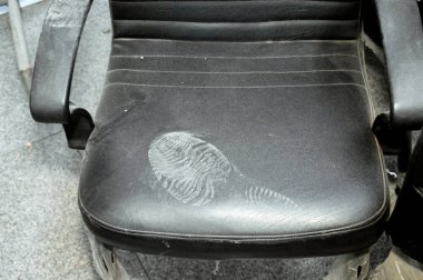 Deri sandalyede ayak izi, tozlu sandalyede kirli ayakkabı izi iz, iz sürme, ayak izi, iz sürme ve olay yeri konsepti, adli tıp ayrıntıları, seçici odaklanma.