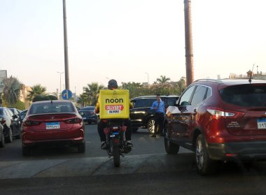 Kahire, Mısır, 22 Ağustos 2023: Öğlen motosiklet teslimat servisi online satın alınmış bir paket için yola çıktı. Öğlen, Arap dünyasında yatırım fonu tarafından Suudi Arabistan 'a ait bir e-ticaret platformu.