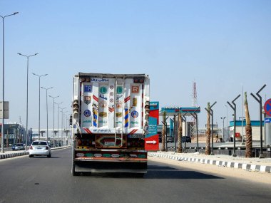 Kahire, Mısır, 21 Ağustos 2023: Mısır 'da Shinzo Abe ekseni devriye otoyolu geleneksel Japon mimari tarzında yaya köprüsü, üzerinde nakliye konteynırı olan düz kamyon büyük aracı