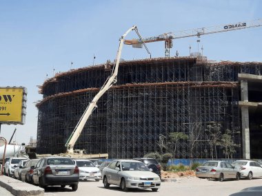 Kahire, Mısır, 6 Ağustos 2023: SAMCO yeni bir binanın şantiyesi, yolun kenarına kamyon monte edilmiş beton pompa yeni binaya beton dökülüyor, Mısır 'daki kalkınma projeleri
