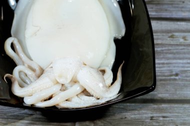 Pişmemiş taze mürekkep balığı, uzamış yumuşak gövdeli yumuşakça, büyük gözler, sekiz kol ve süper düzen Decapodiformes 'taki iki dokunaç mürekkep balığı kamuflaj ve sinyal için renk değiştirebilir.