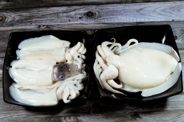 Pişmemiş taze mürekkep balığı, uzamış yumuşak gövdeli yumuşakça, büyük gözler, sekiz kol ve süper düzen Decapodiformes 'taki iki dokunaç mürekkep balığı kamuflaj ve sinyal için renk değiştirebilir.