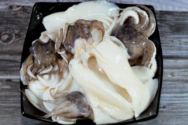 Pişmemiş taze mürekkep balığı, uzamış yumuşak gövdeli yumuşakça, büyük gözler, sekiz kol ve süper düzen Decapodiformes 'taki iki dokunaç mürekkep balığı kamuflaj ve sinyal için renk değiştirebilir.