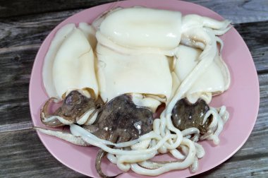 Pişmemiş taze mürekkep balığı, uzamış yumuşak gövdeli yumuşakça, büyük gözler, sekiz kol ve süper düzen Decapodiformes 'taki iki dokunaç mürekkep balığı kamuflaj ve sinyal için renk değiştirebilir.