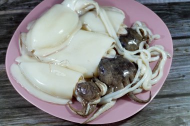 Pişmemiş taze mürekkep balığı, uzamış yumuşak gövdeli yumuşakça, büyük gözler, sekiz kol ve süper düzen Decapodiformes 'taki iki dokunaç mürekkep balığı kamuflaj ve sinyal için renk değiştirebilir.