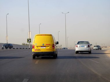 Kahire, Mısır, 31 Ağustos 2023: DHL kamyonu bir paket teslimatı yapıyor, DHL uluslararası nakliye, kurye hizmetleri ve taşımacılık alanında uzmanlaşmış lojistik sektöründe küresel lider.