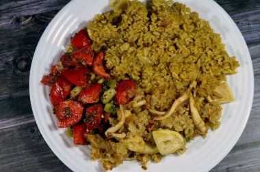 Bir tabak sıcak kırmızı pirinç, yeşil salata ve kızarmış kalamar, uzamış yumuşak gövdeli bir yumuşakça, büyük gözler, sekiz kol, ve iki dokunaç süper sipariş Decapodiformes, seçici odaklı