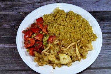 Bir tabak sıcak kırmızı pirinç, yeşil salata ve kızarmış kalamar, uzamış yumuşak gövdeli bir yumuşakça, büyük gözler, sekiz kol, ve iki dokunaç süper sipariş Decapodiformes, seçici odaklı