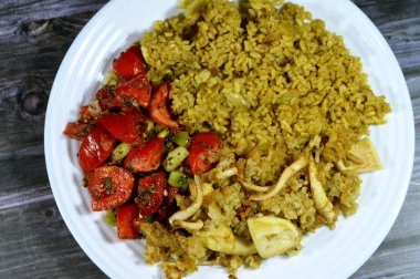 Bir tabak sıcak kırmızı pirinç, yeşil salata ve kızarmış kalamar, uzamış yumuşak gövdeli bir yumuşakça, büyük gözler, sekiz kol, ve iki dokunaç süper sipariş Decapodiformes, seçici odaklı